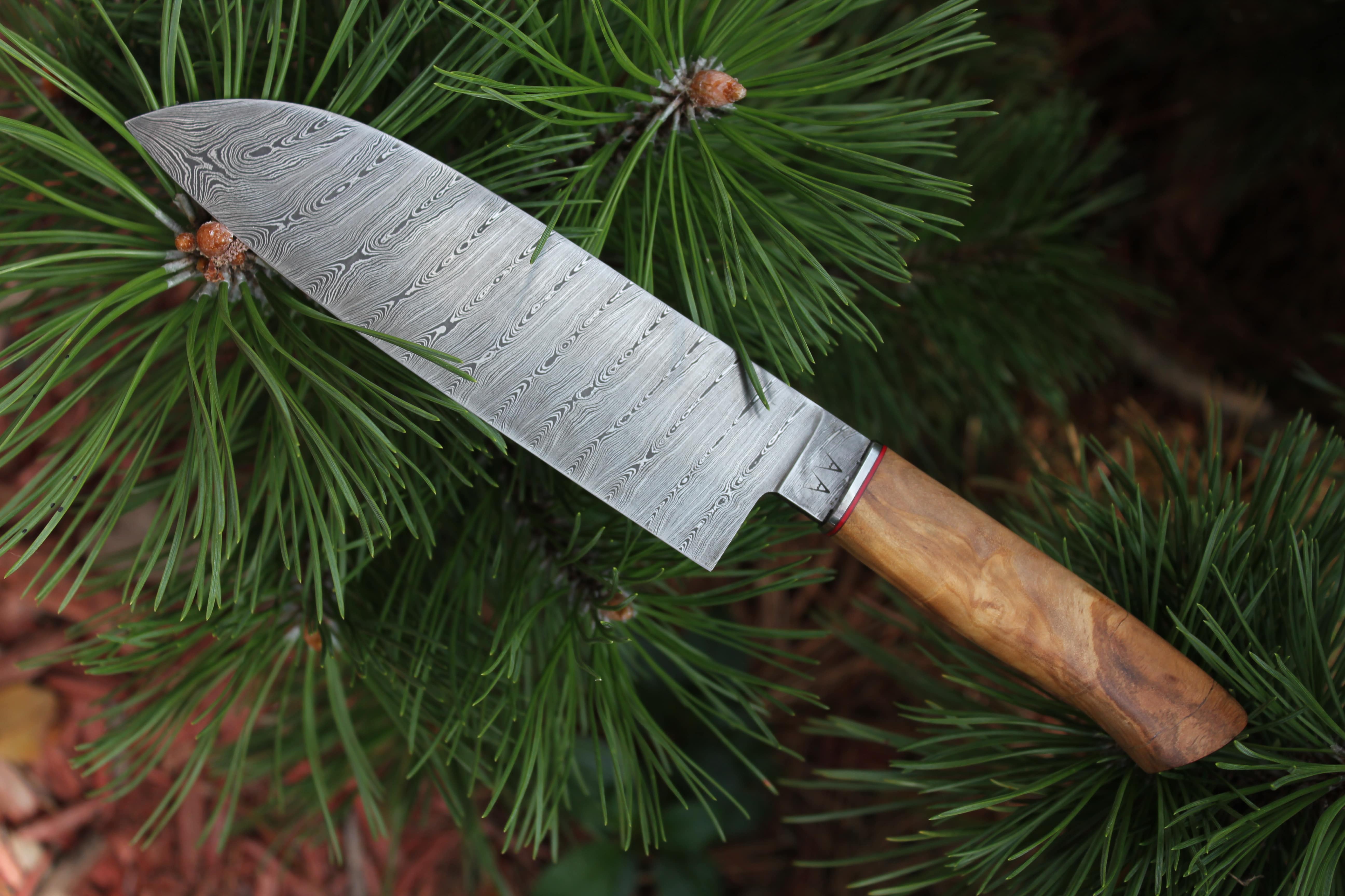A custom 192-layer Damascus steel santoku with an Olivewood handle.