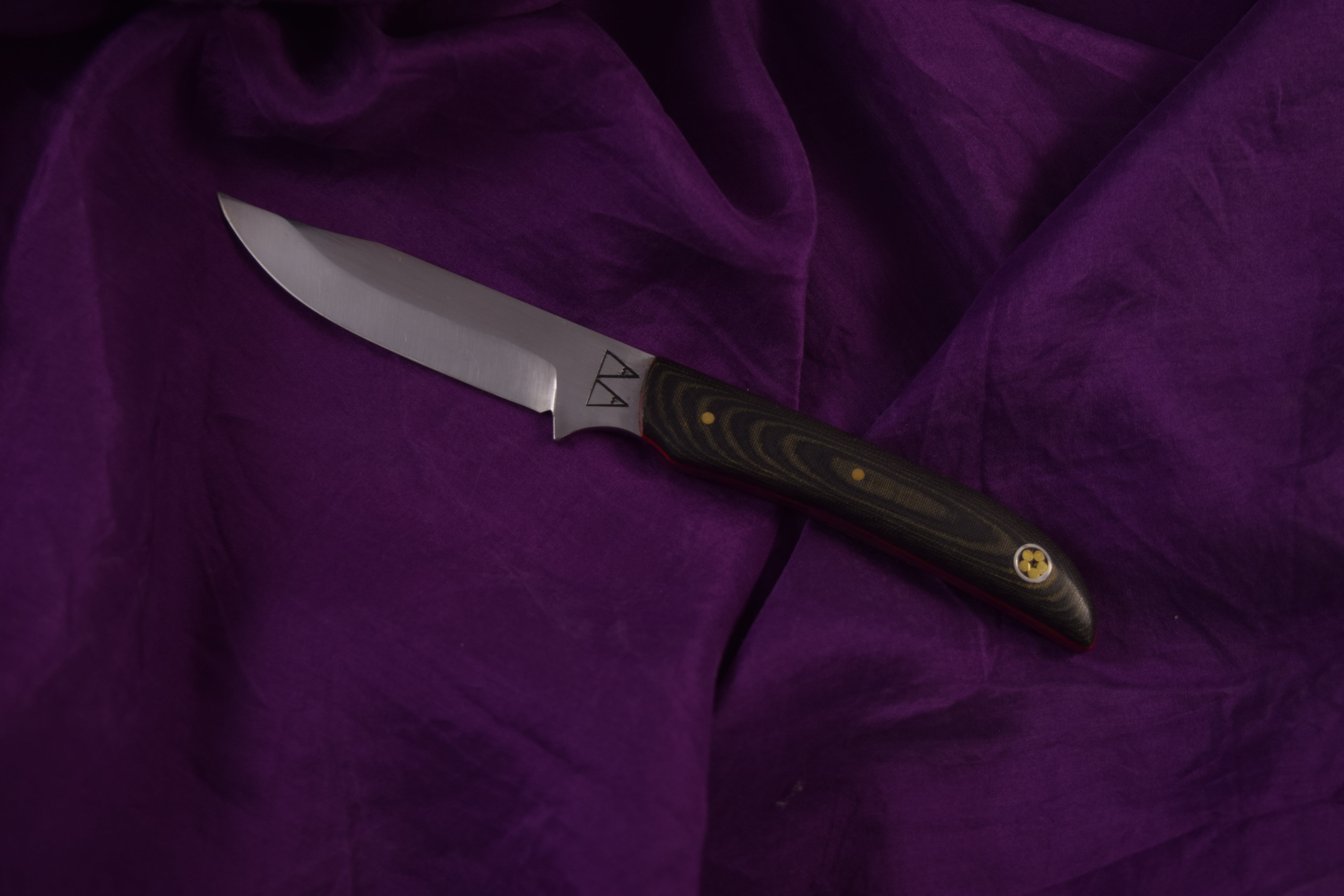 A custom skinning knife with a Mukwa handle and copper bolster.