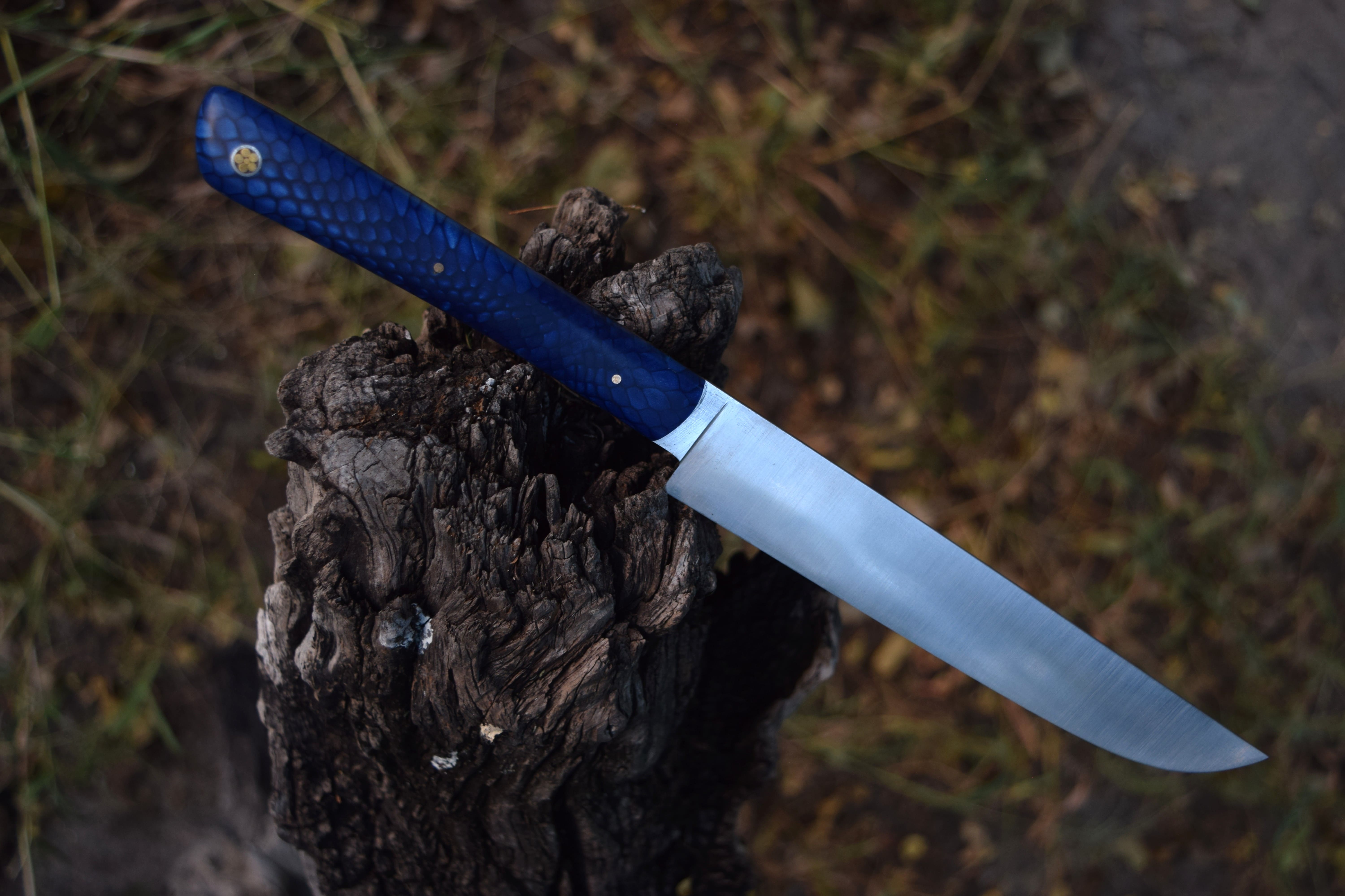 A camp chopper with a Warthog tusk handle and a copper and ebony bolster.